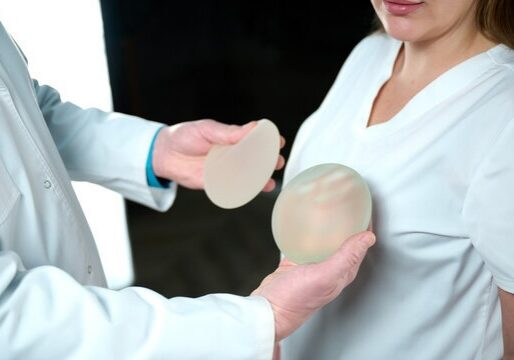 Plastic surgeon holds silicone breast implants.